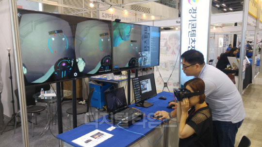 아프리카TV는 지난 22일부터 24일까지 일산 킨텍스(KINTEX)에서 열린 가상현실·증강현실(VR·AR)분야 국제 컨퍼런스 '2016 VR 서미트(Summit)' 행사에서 VR 게임 화면을 아프리카TV를 통해 송출하는 생방송을 진행했다. 현장 방문객이 아프리카TV를 통해 게임 개발사 볼트홀의 VR 게임을 체험하고 있다. <아프리카TV 제공>